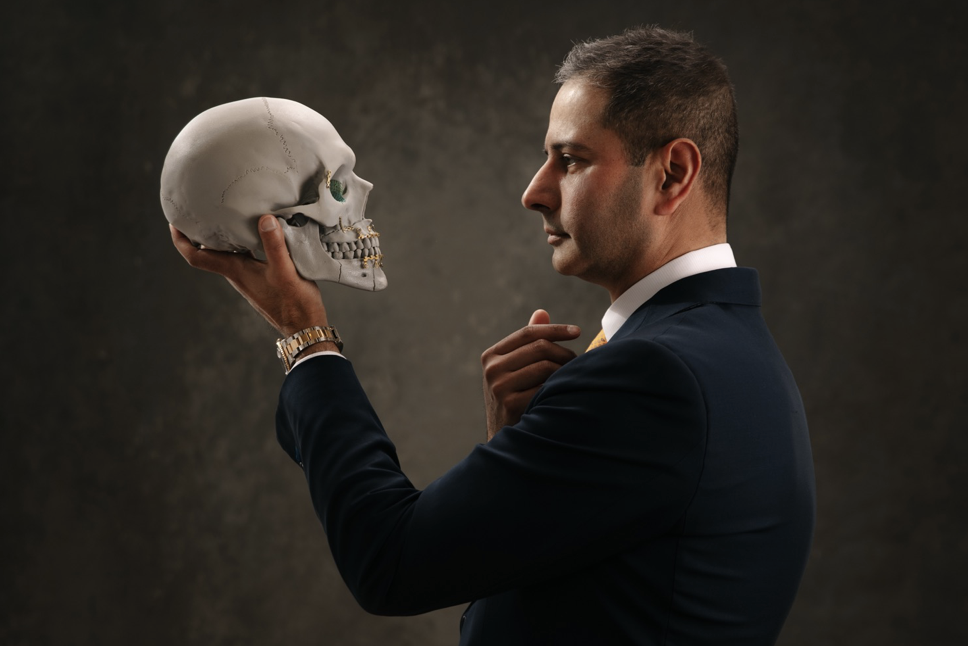 Dr Navin Singh in a suit holding a skull