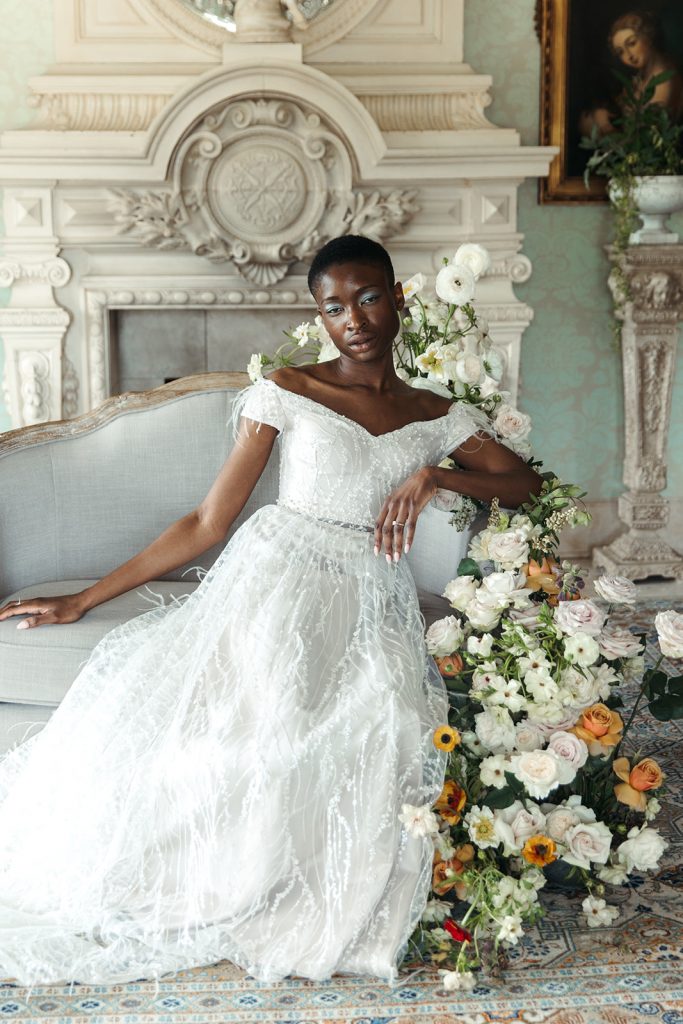 A bride poses on an elegant couch during an editorial wedding shoot