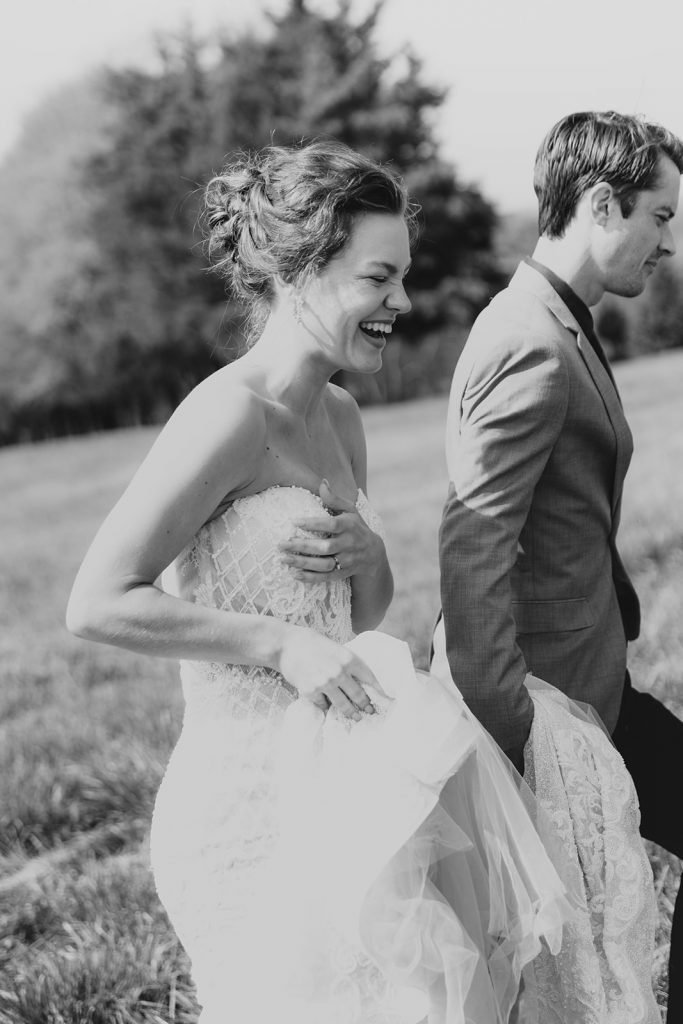 A black and white image of a couple smiling and laughing during their editorial wedding