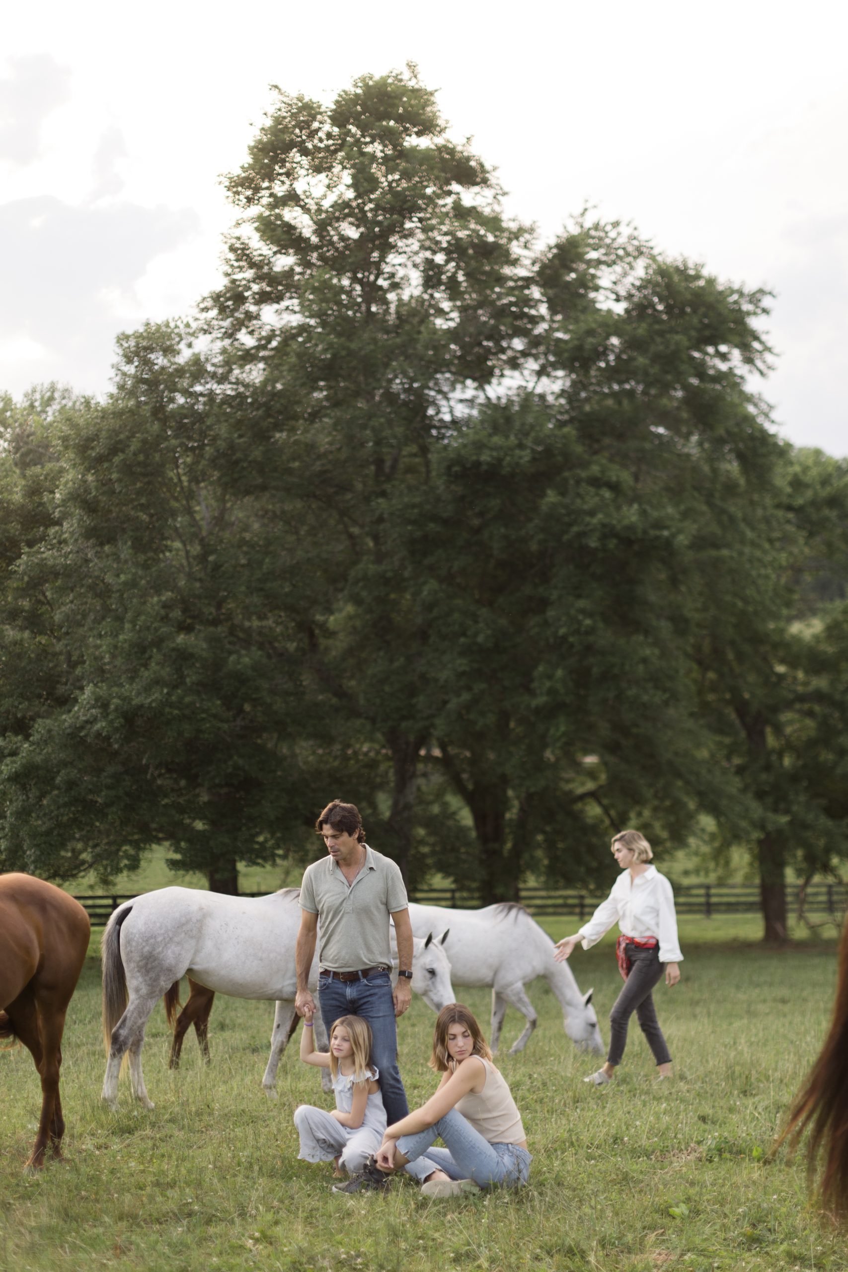 a family walking with horses in a field