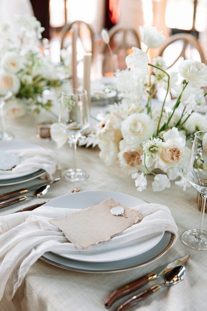 19 Luxury Wedding Ideas for an Elegant Celebration. Close-up of the wedding reception table with floral arrangements and utensils.