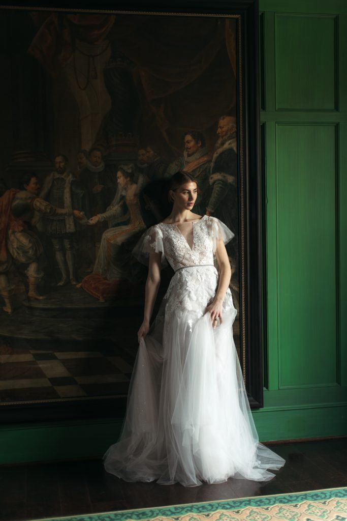 Elegant bride leaning against a beautiful wall painting