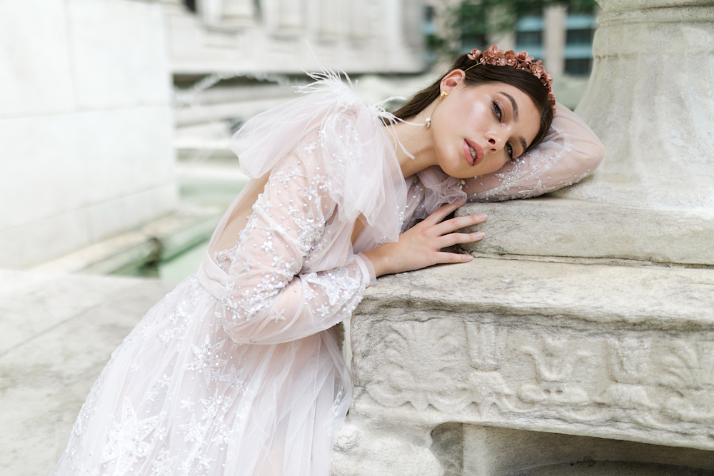Bride in Kim Kassas Couture looking effortlessly stunning as she rests her head against a statue outside of the New York Public Library, captured by Washington DC wedding photographer Kyla Jeanette
