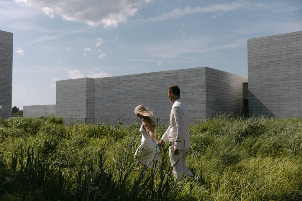 Bride and groom running along the grass while holding hands, taken by Kyla Jeanette Photography