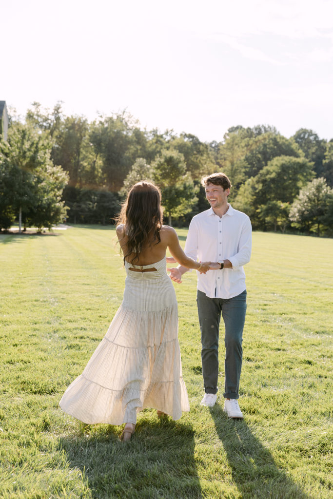Couple smiling at each other and holding hands during their Salamander Resort engagement session with Kyla Jeanette Photography
