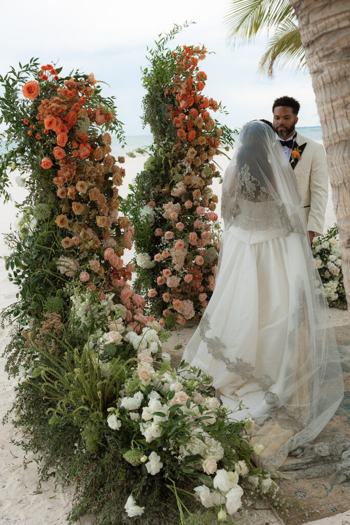 Lauren and Lee in a wedding dress beside flowers
